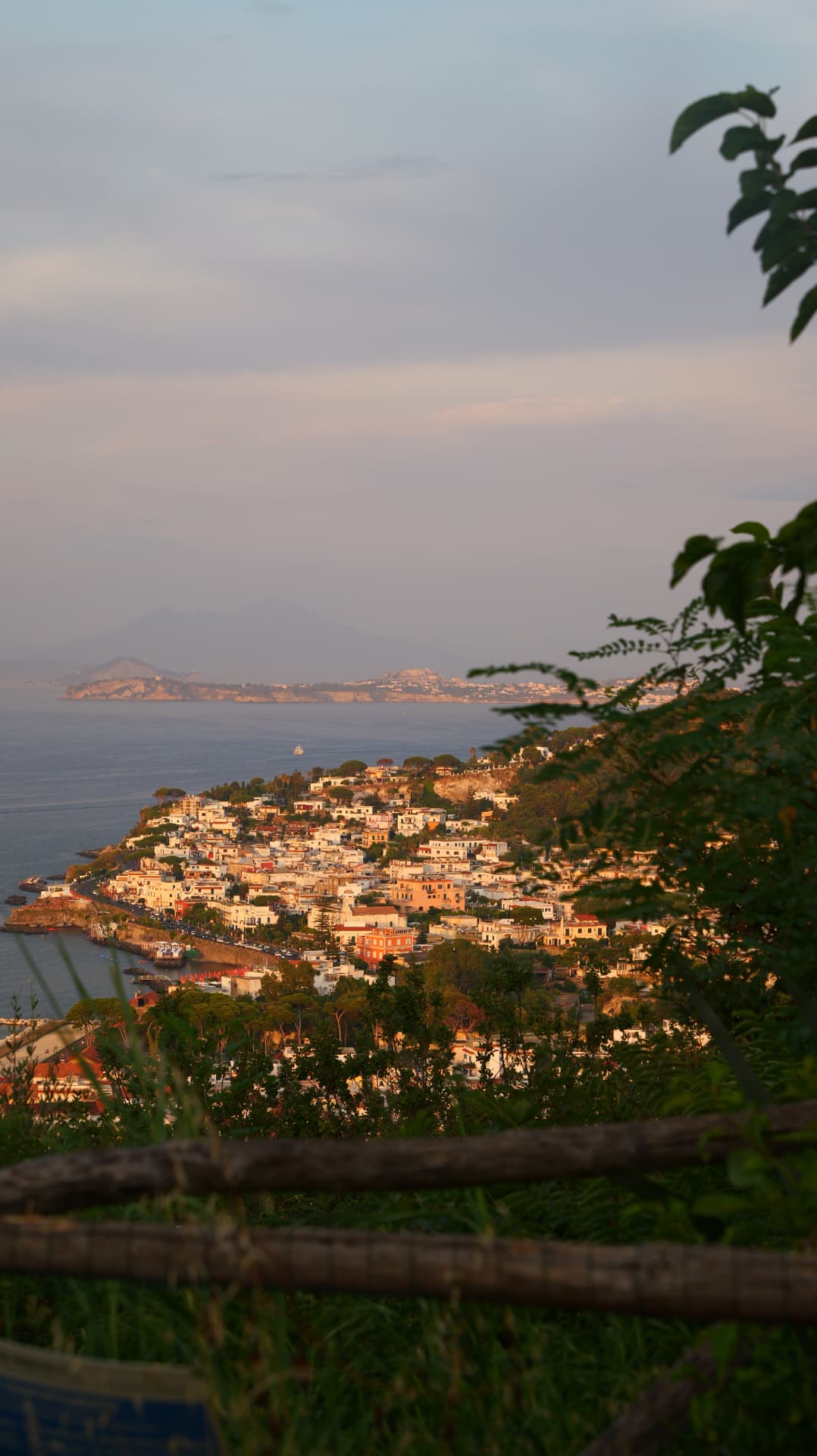 Coastal town on a headland in golden evening light with Vesuvius beyond
