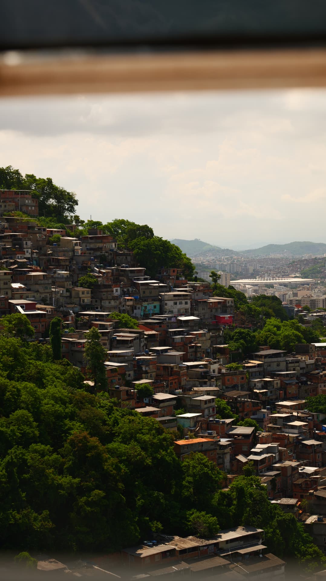 Favela houses climbing a green hillside above Rio de Janeiro