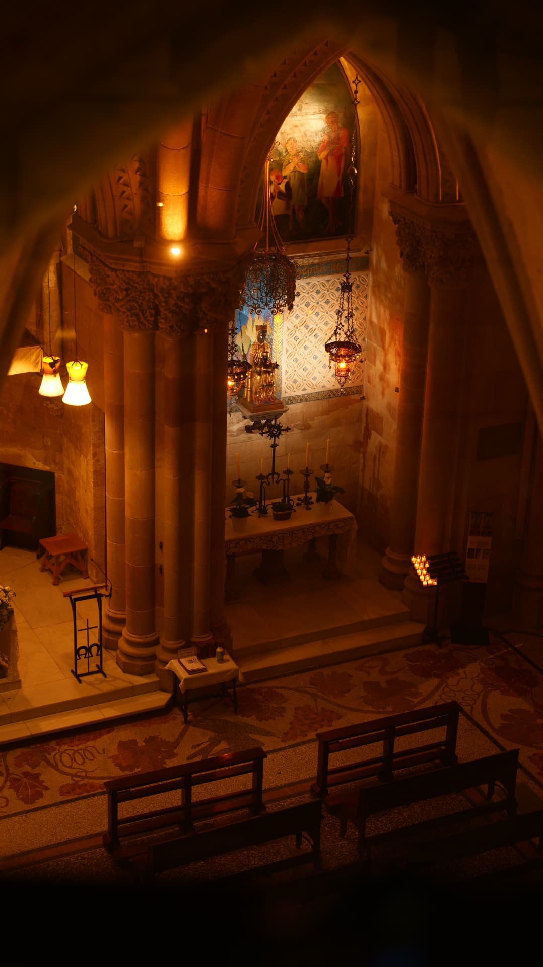 Candlelit stone chapel with hanging lanterns and a small altar
