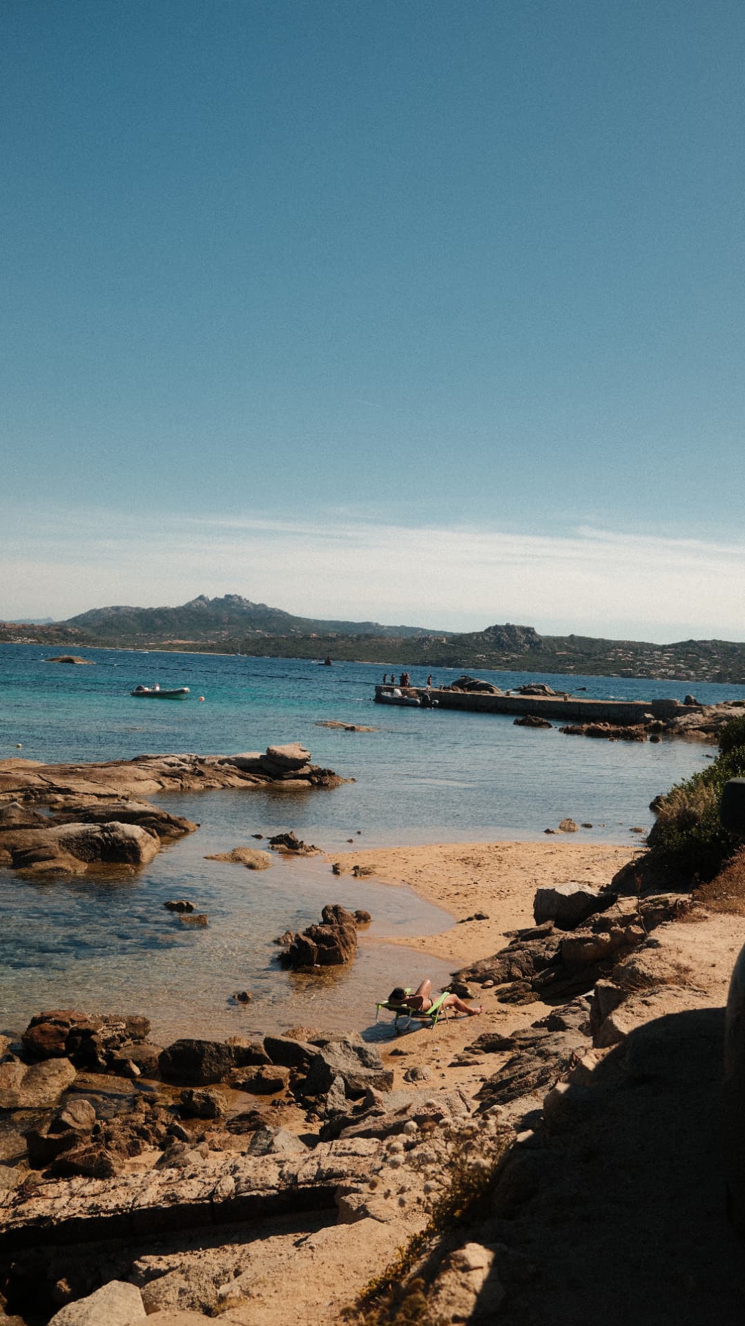 Rocky cove with clear shallow water and a small sandy beach