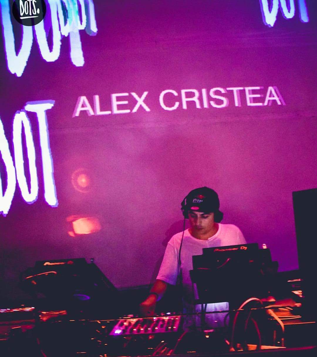 Alex Cristea at the decks with his name projected in pink