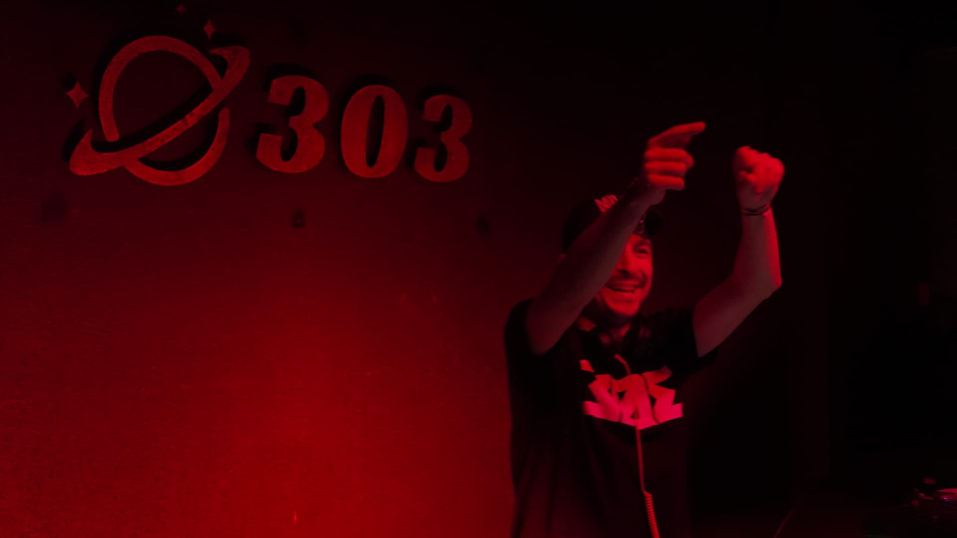 Alex Cristea with arms up in red light at 303