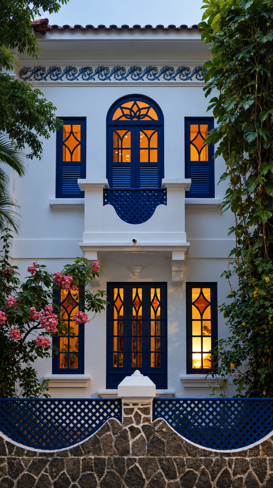 Colonial facade in Rio de Janeiro with deep-blue shutters, orange window light and a lattice balcony at dusk