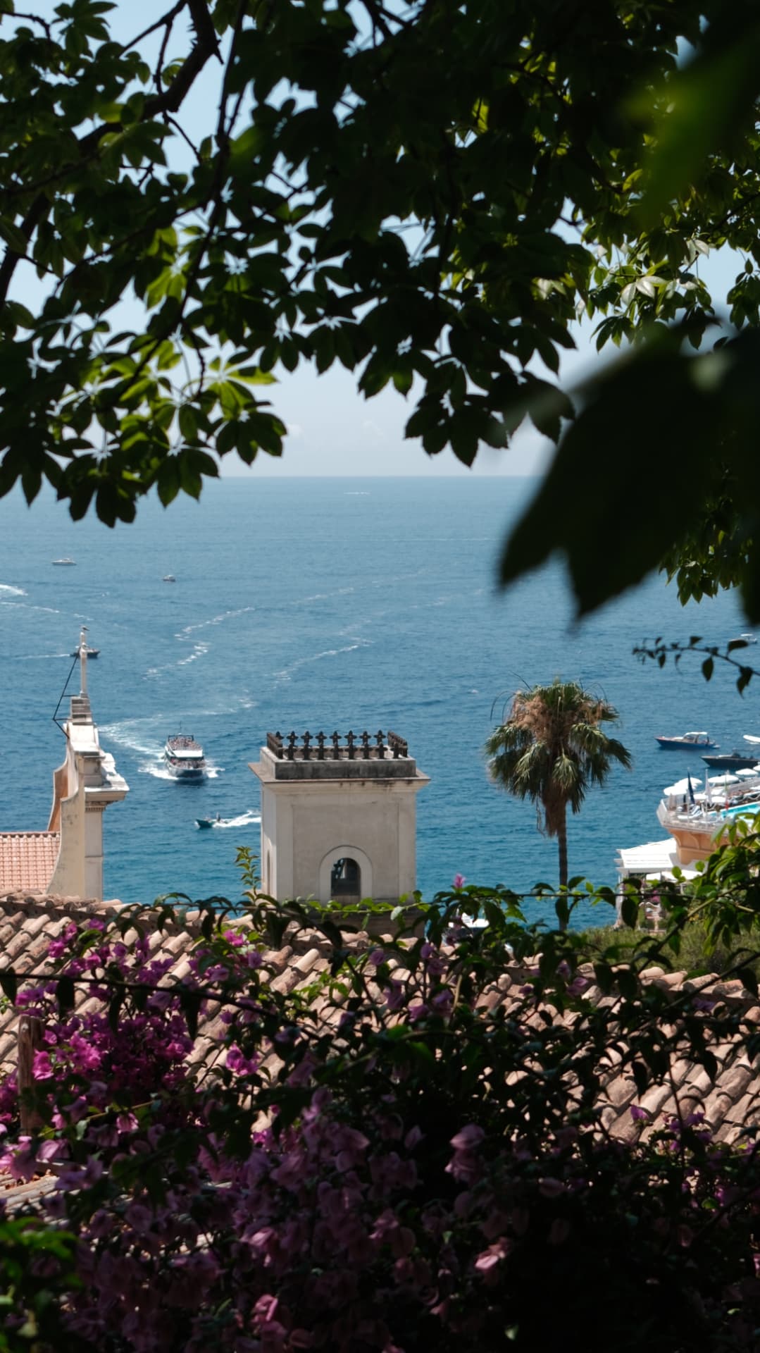 Bell tower and bougainvillea framing the blue sea on the Amalfi coast