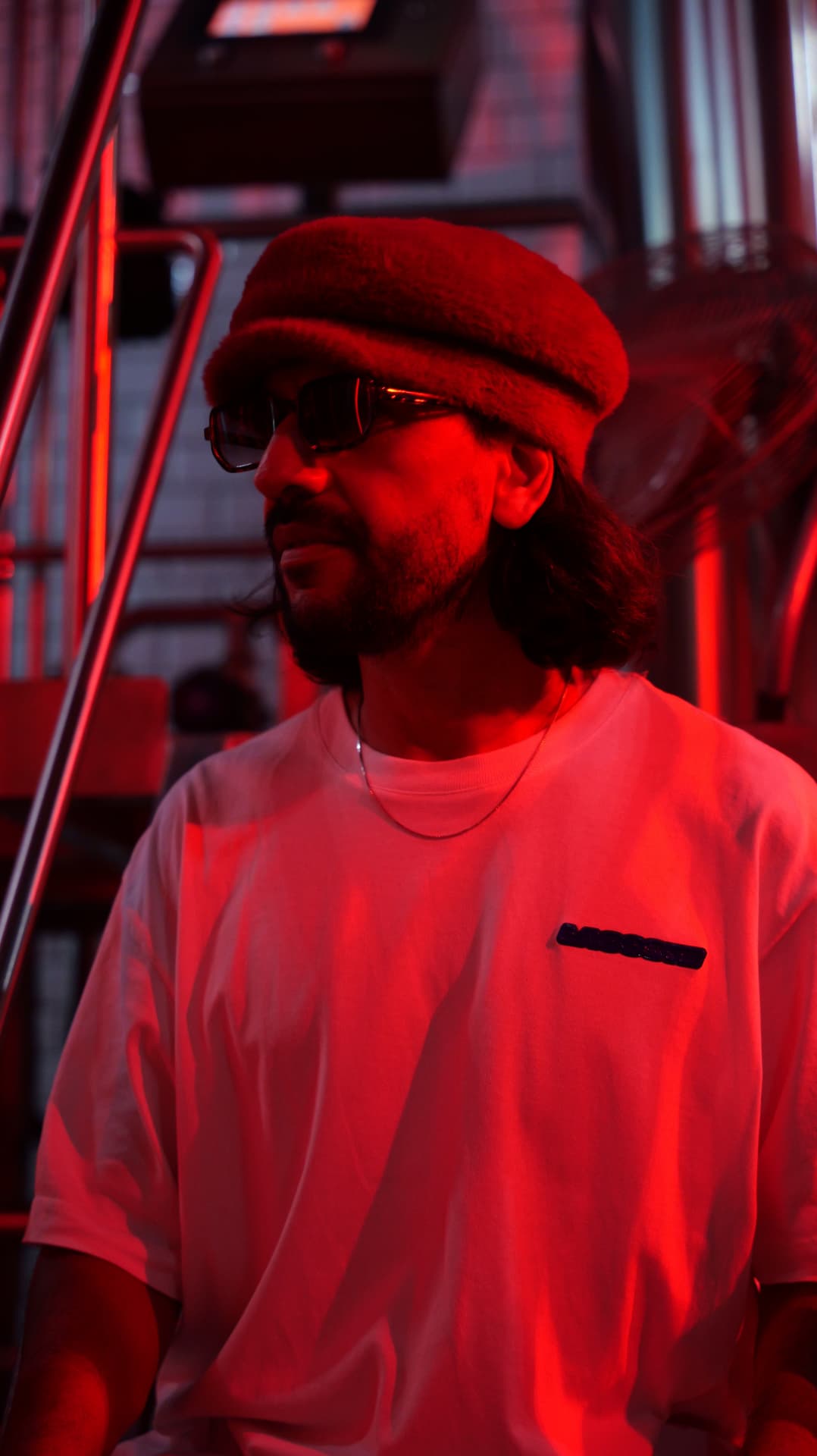 Side profile of a man in a beret in deep red light
