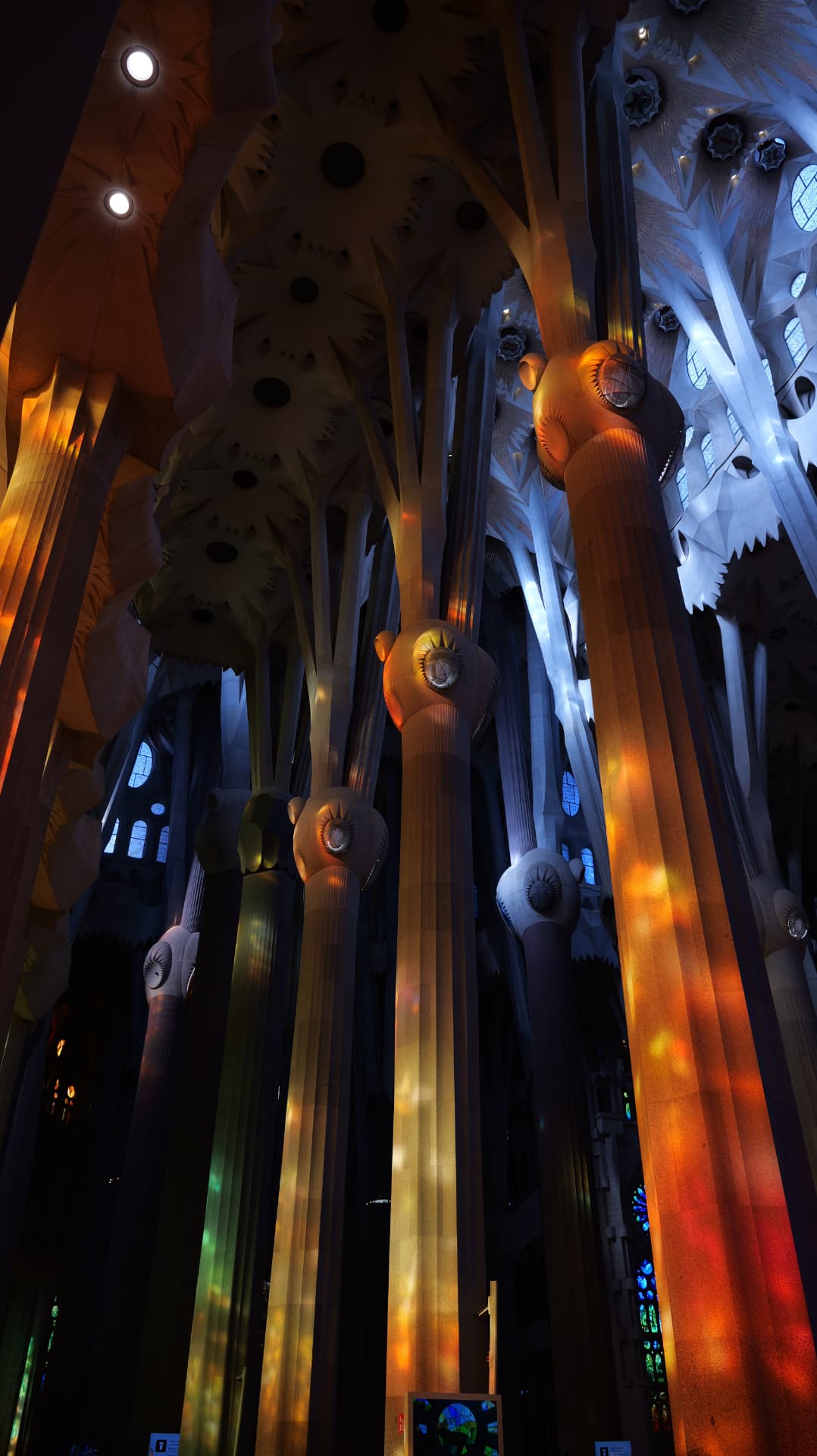 Stone canopy and stained glass seen from below inside the Sagrada Família