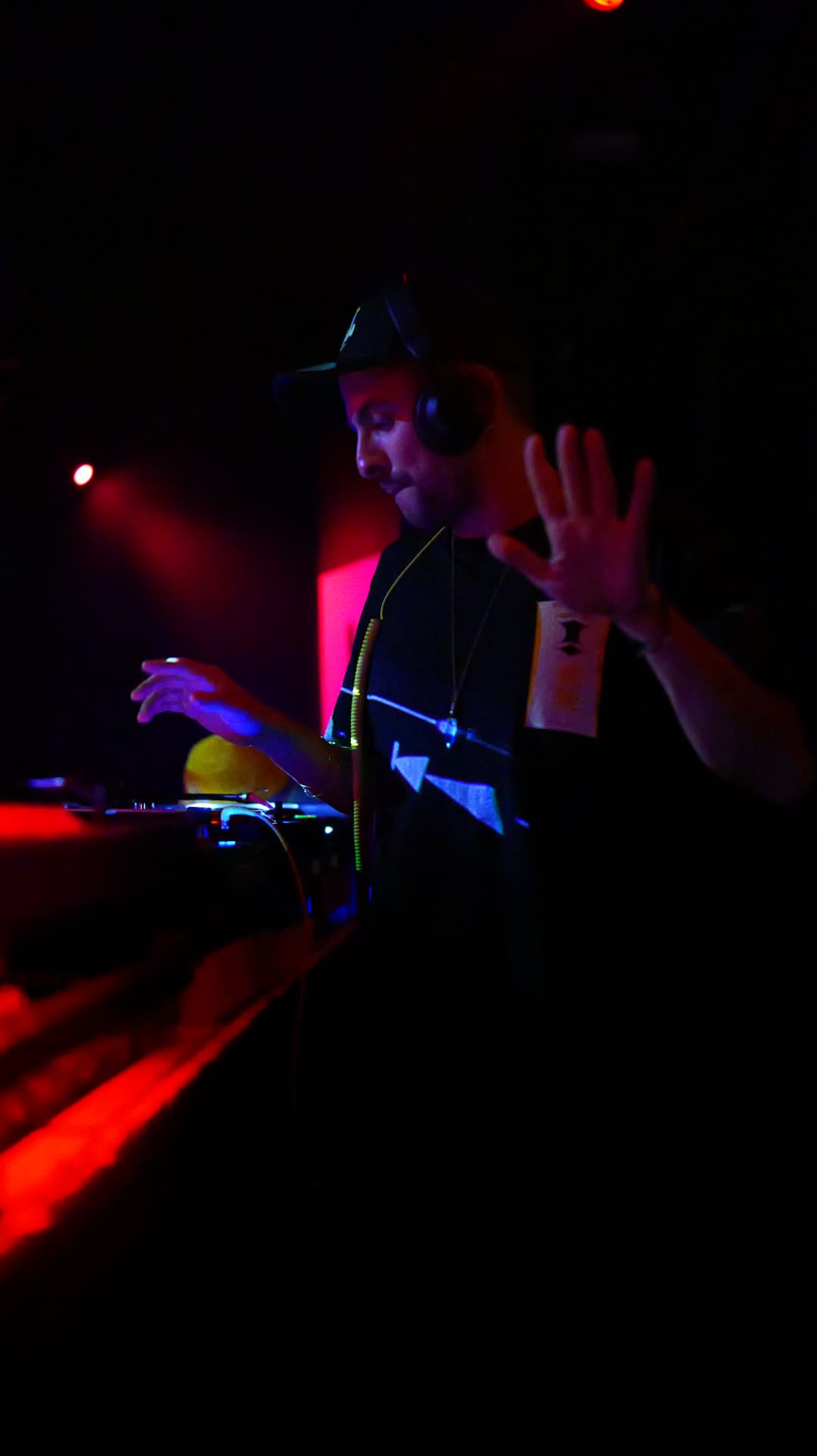 Alex Cristea at the decks under red club light