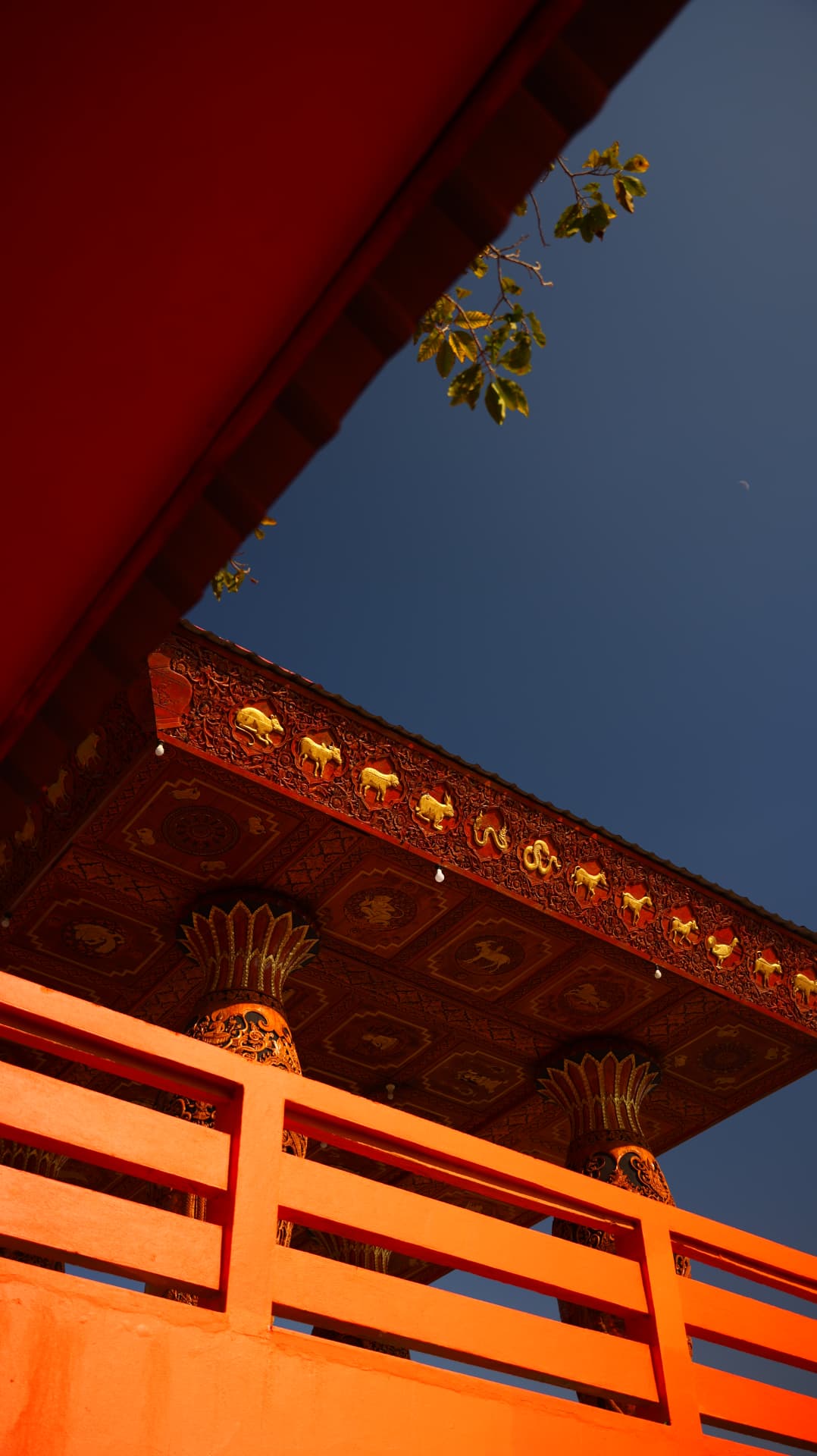 Temple eave with gold zodiac reliefs against blue sky