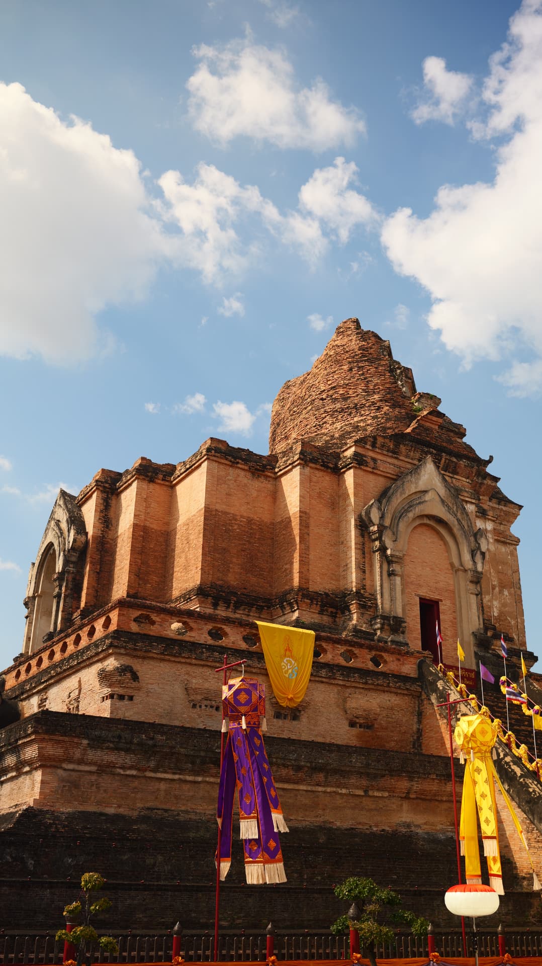 Brick stupa of Wat Chedi Luang with festival banners under a blue sky