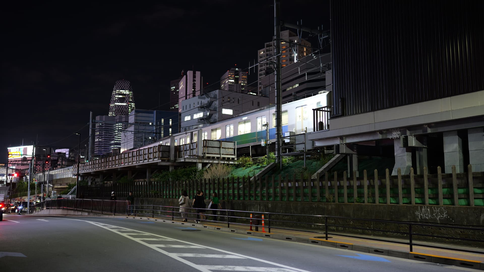 Tokyo train passing illuminated towers and railway lines at night