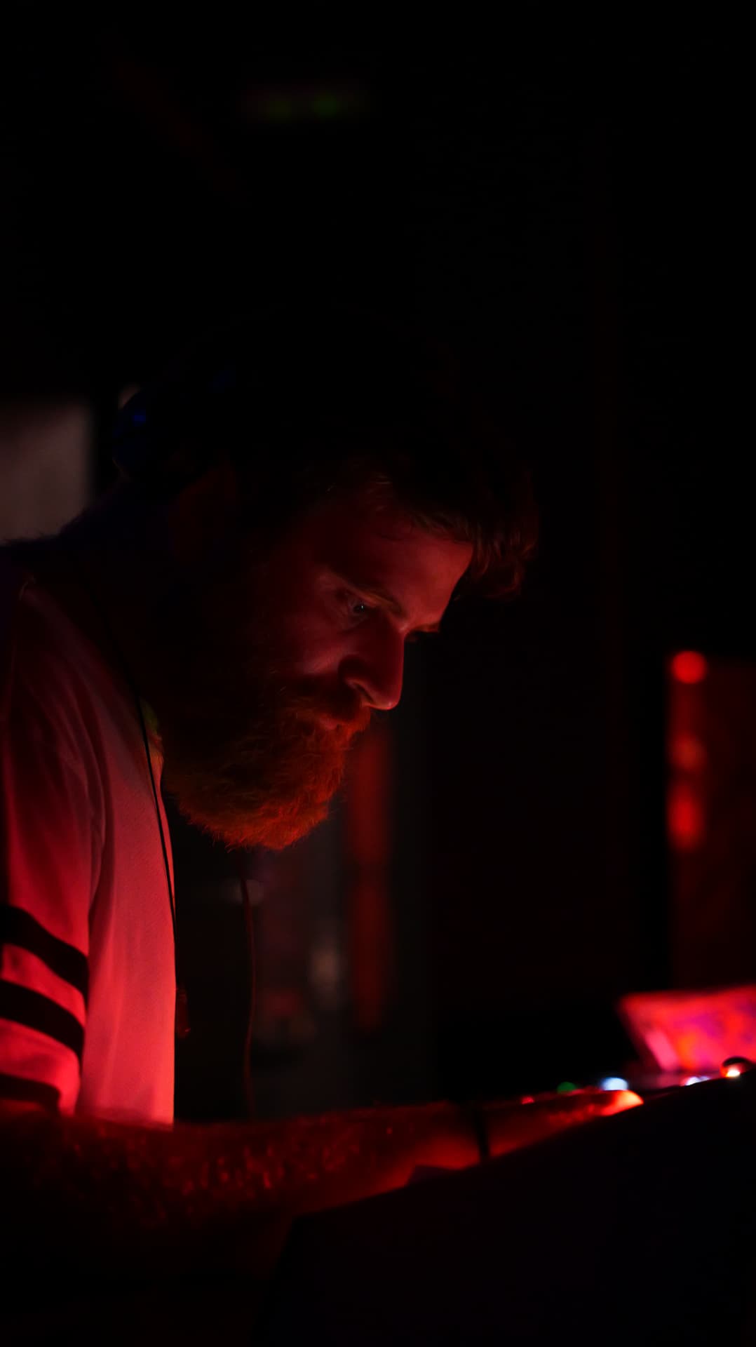 Bearded man looking down in deep red low light